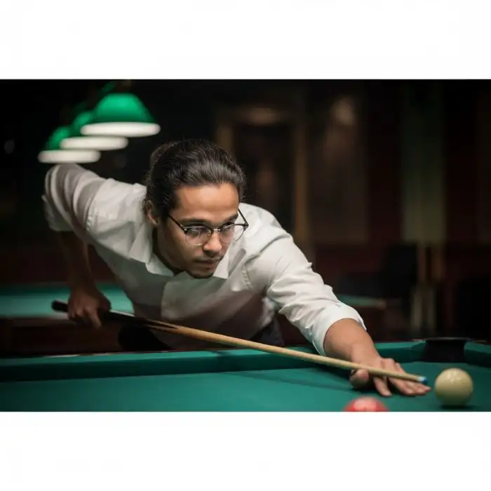 Close-up cinematic portrait of a man, Nahid Hasan Mim, leaning over a billiard table, concentrating on a pool shot under the green table lights.