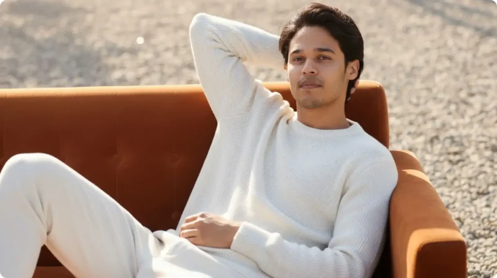 Gemini AI Photo Prompt: A man, Nahid Hasan Mim, transforms from a plain studio portrait (Age) into a relaxing, iconic movie star frame on an outdoor velvet sofa (Pore).